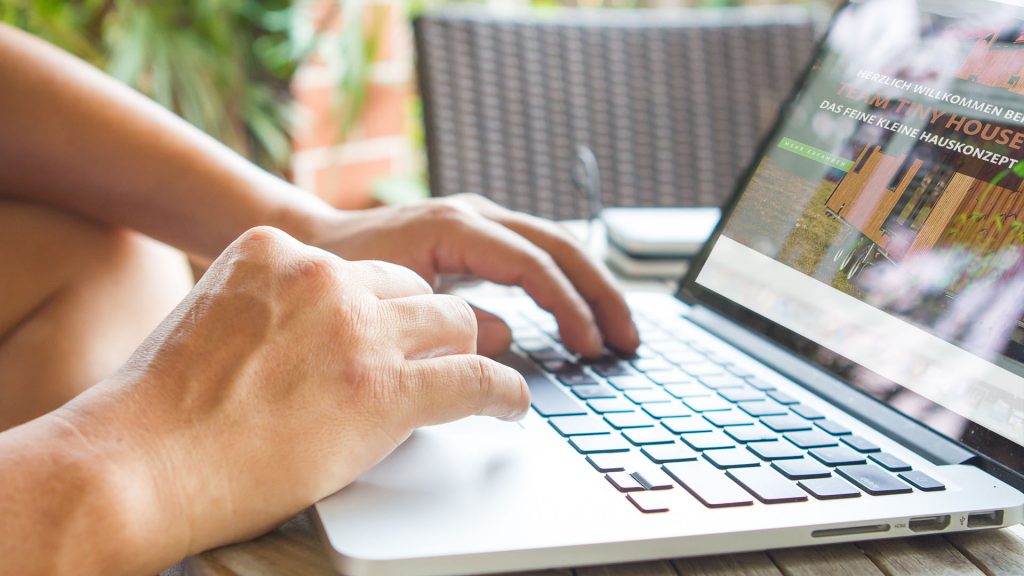 Team-tiny-house-kontakt- person an Notebook- im- bildschirm- ist die startseite zu sehen
